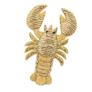 Gold lobster-shaped decorative item on a white background