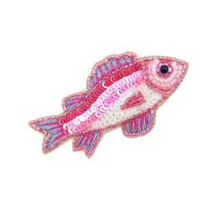 Decorative fish-shaped object with pink and blue patterns on a light background